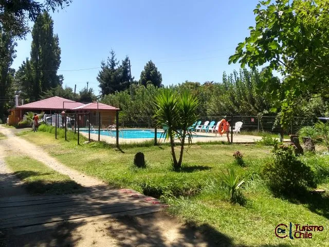 Vista de la piscina con gazebo y reposeras de Cabañas La Chinita